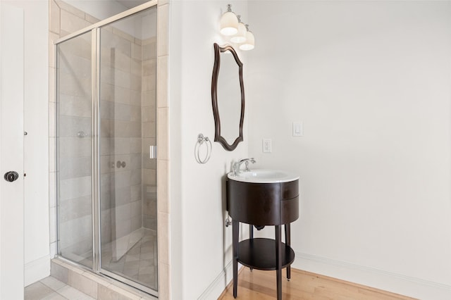 bathroom with hardwood / wood-style flooring and a shower with shower door