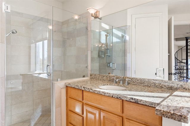 bathroom featuring a shower with door and vanity