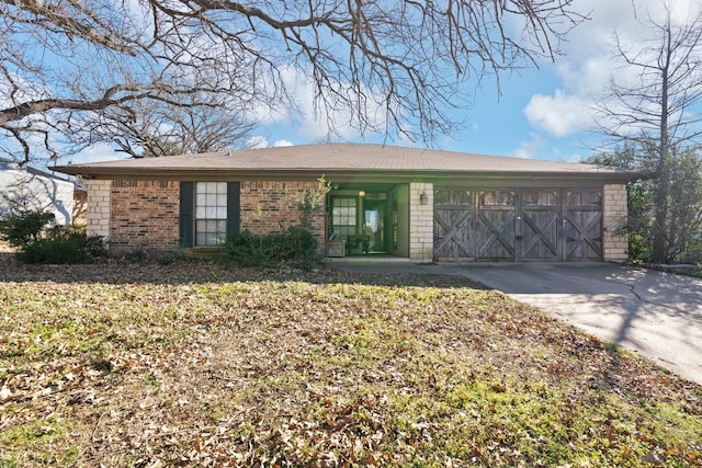 ranch-style home with concrete driveway, brick siding, and an attached garage