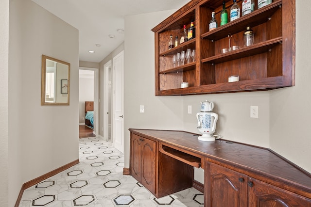 interior space with built in desk and baseboards