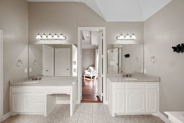 full bath featuring tile patterned flooring, vaulted ceiling, two vanities, and a sink