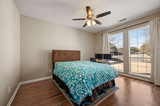 bedroom with ceiling fan, wood finished floors, visible vents, and baseboards