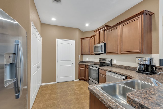 kitchen with light tile patterned flooring, appliances with stainless steel finishes, and sink