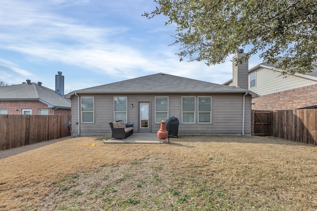 rear view of house with a patio and a lawn