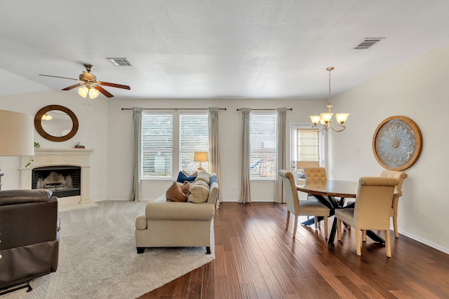 interior space with ceiling fan with notable chandelier, dark wood-type flooring, and a textured ceiling