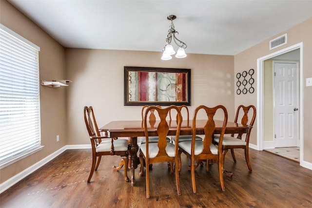 dining space with dark wood finished floors, visible vents, and baseboards