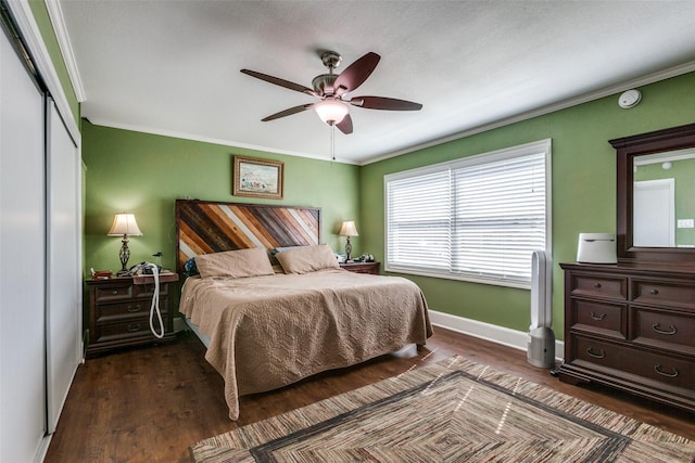 bedroom featuring ceiling fan, baseboards, ornamental molding, a closet, and dark wood-style floors