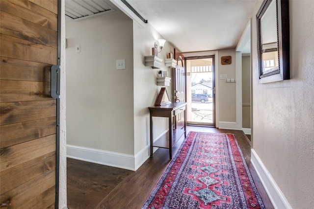 entryway with dark wood finished floors and baseboards