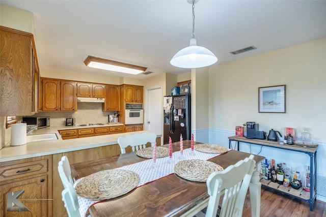 dining room with sink and dark wood-type flooring