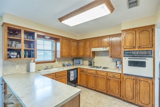 kitchen featuring sink, white appliances, tasteful backsplash, and kitchen peninsula