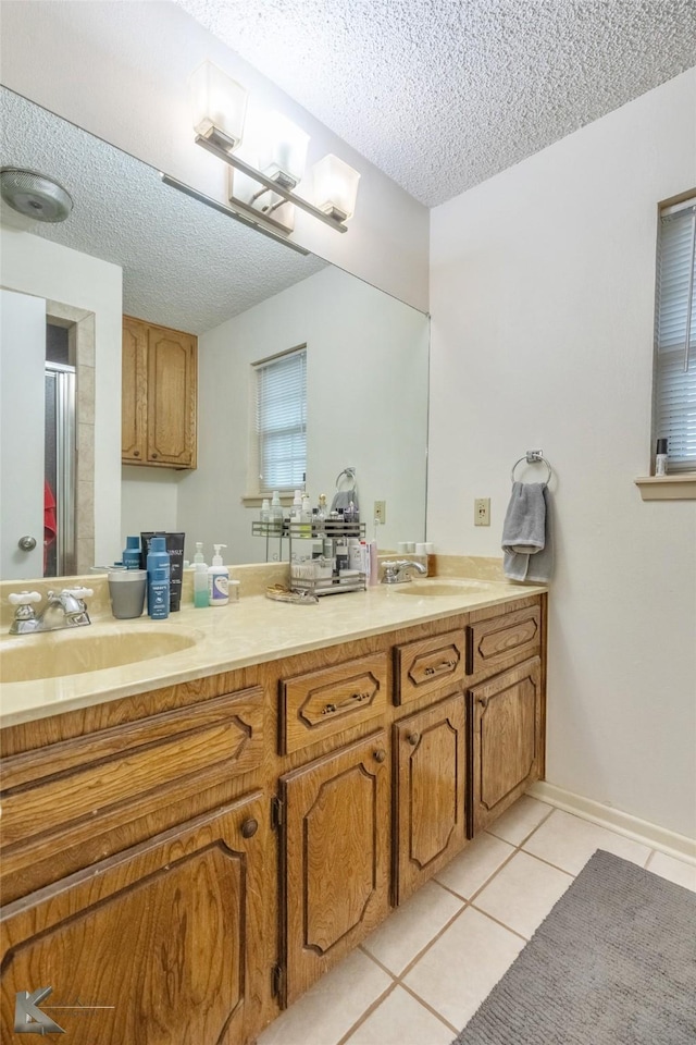 bathroom featuring tile patterned flooring, vanity, and a textured ceiling