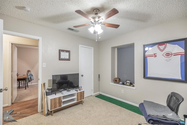 office space featuring ceiling fan, carpet, and a textured ceiling