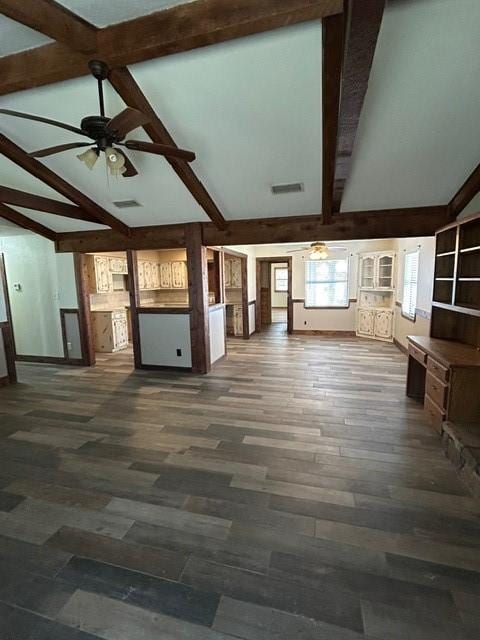 unfurnished living room featuring ceiling fan, dark wood-type flooring, and lofted ceiling with beams