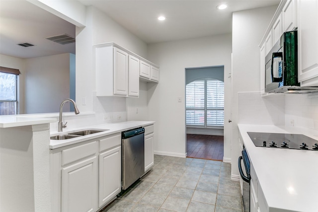 kitchen featuring sink, tasteful backsplash, black appliances, and white cabinetry