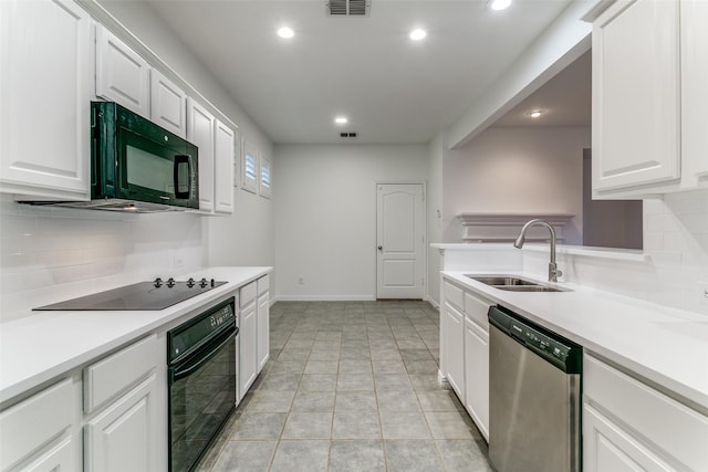 kitchen featuring white cabinets, black appliances, light tile patterned flooring, backsplash, and sink