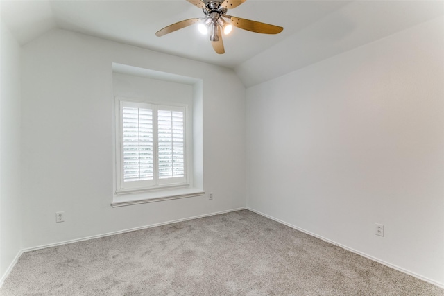 spare room featuring vaulted ceiling, ceiling fan, and light colored carpet