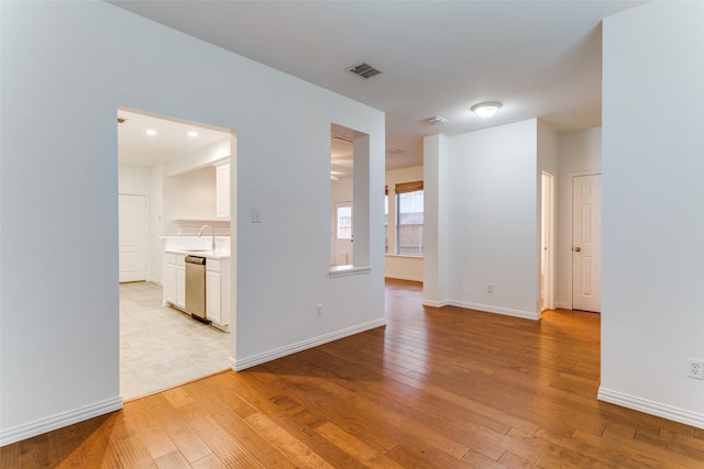 empty room with sink and light hardwood / wood-style floors