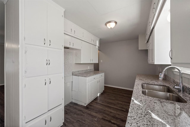 kitchen with sink, white cabinetry, and light stone countertops