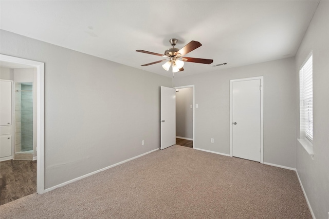 unfurnished bedroom featuring carpet, ensuite bathroom, and ceiling fan