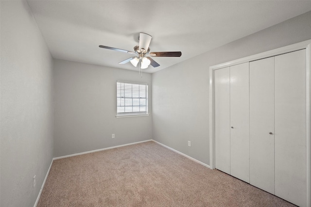 unfurnished bedroom with ceiling fan, a closet, and light colored carpet