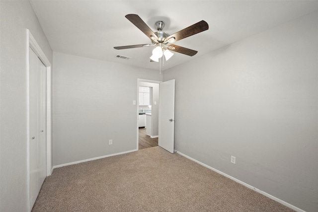 unfurnished bedroom with carpet floors, a closet, and ceiling fan