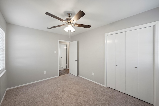 unfurnished bedroom featuring carpet, a closet, and ceiling fan