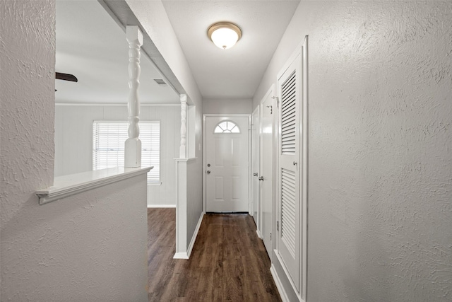 doorway featuring dark hardwood / wood-style flooring and decorative columns