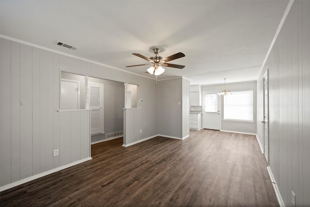 unfurnished living room featuring ceiling fan with notable chandelier, dark wood-type flooring, and ornamental molding