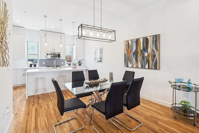 dining space featuring light wood-type flooring, baseboards, and recessed lighting