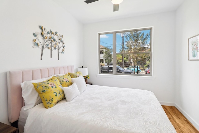 bedroom featuring ceiling fan, wood finished floors, and baseboards