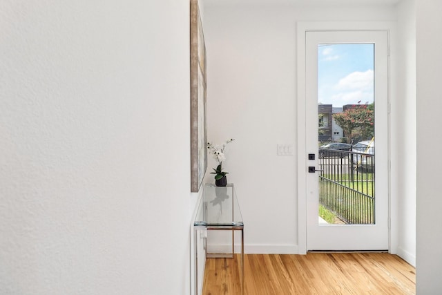 doorway to outside featuring light wood-style flooring and baseboards