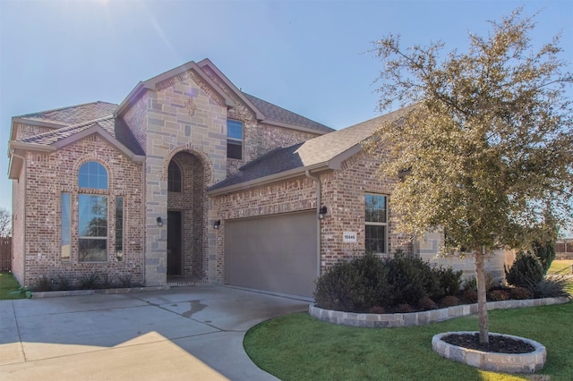 view of front of house with a garage, driveway, brick siding, and a front lawn