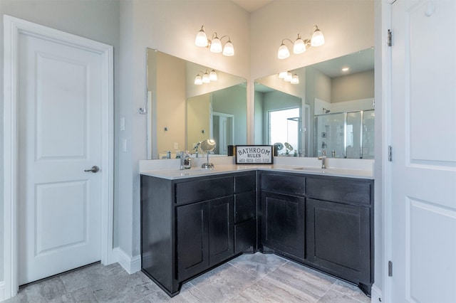 bathroom featuring double vanity, a stall shower, and a sink