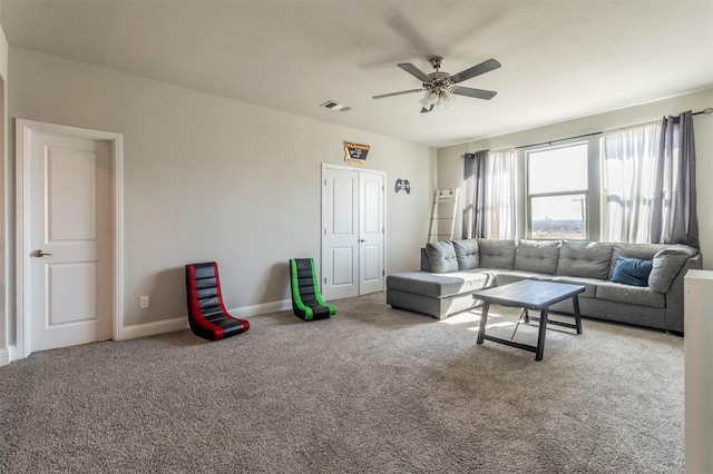 living room with baseboards, carpet, visible vents, and a ceiling fan