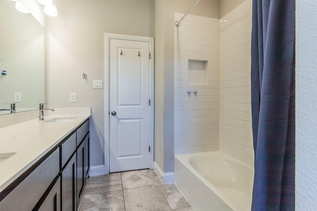 bathroom with a sink, shower / bathtub combination with curtain, baseboards, and double vanity