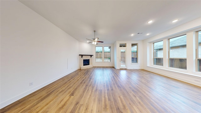 unfurnished living room featuring ceiling fan and light hardwood / wood-style flooring