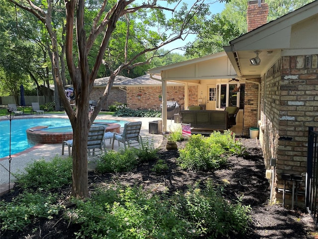 view of yard with outdoor lounge area, a fenced in pool, ceiling fan, and a patio area