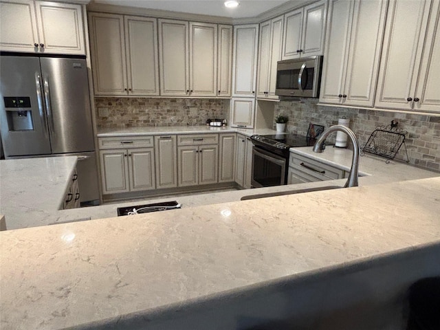 kitchen with decorative backsplash, sink, stainless steel appliances, and light stone counters