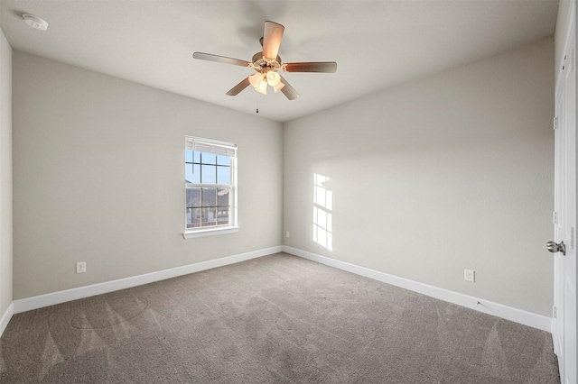 carpeted empty room with ceiling fan and baseboards