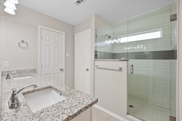 bathroom with tile patterned floors, a shower with shower door, and vanity