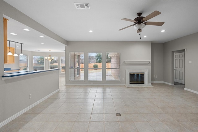 unfurnished living room featuring ceiling fan with notable chandelier and light tile patterned floors