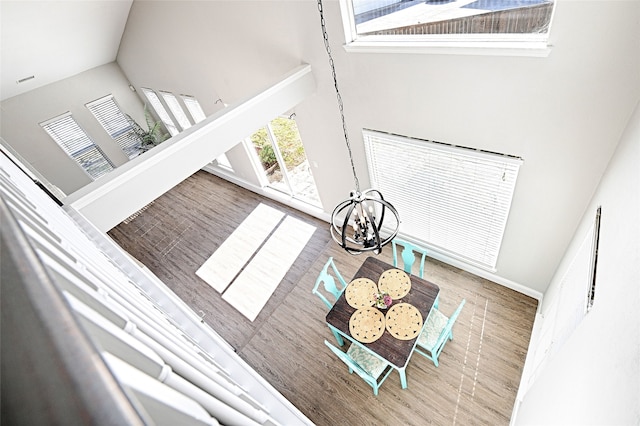 2529 Guerrero Dr, Carrollton, TX 75006 - unfurnished living room featuring baseboards, wood finished floors, high vaulted ceiling, and a notable chandelier