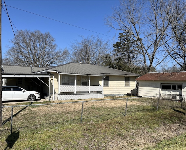 view of front facade with metal roof, an attached carport, and a fenced front yard