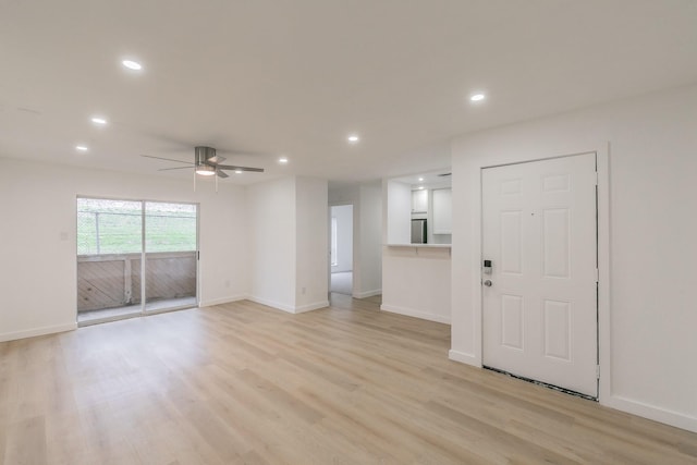 unfurnished living room featuring a ceiling fan, recessed lighting, light wood-style flooring, and baseboards