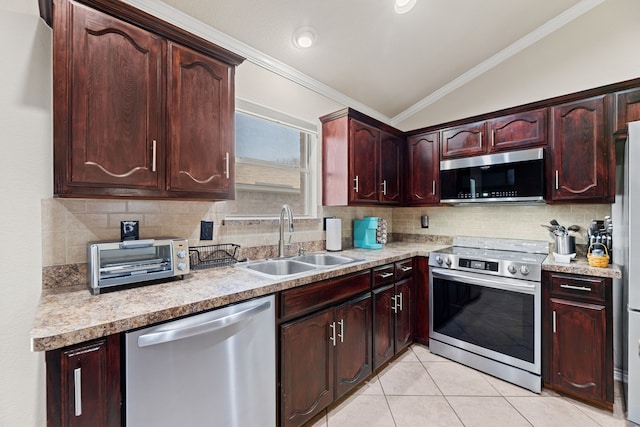 kitchen featuring appliances with stainless steel finishes, lofted ceiling, decorative backsplash, crown molding, and sink