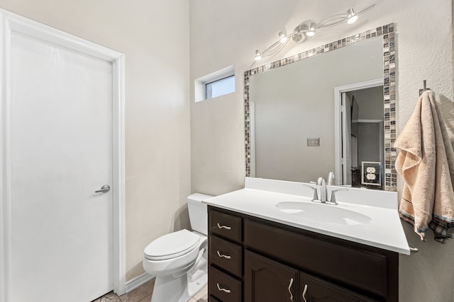 bathroom featuring toilet, vanity, and tile patterned flooring