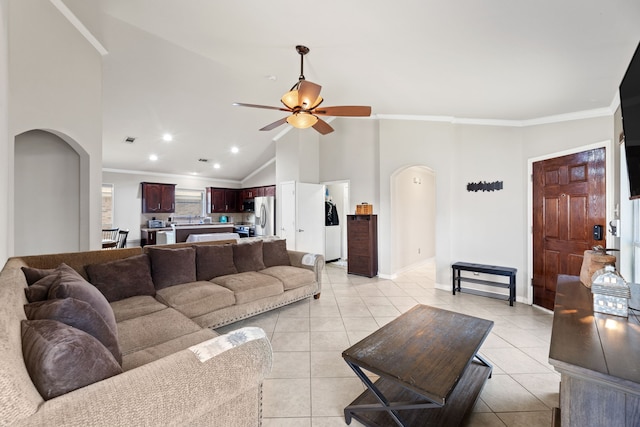 tiled living room featuring ceiling fan, high vaulted ceiling, and crown molding