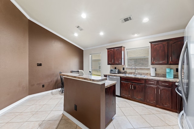 kitchen with appliances with stainless steel finishes, ornamental molding, light tile patterned floors, a kitchen island, and sink