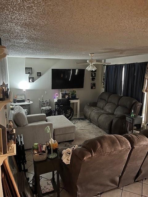 living room featuring ceiling fan, a textured ceiling, and tile patterned floors