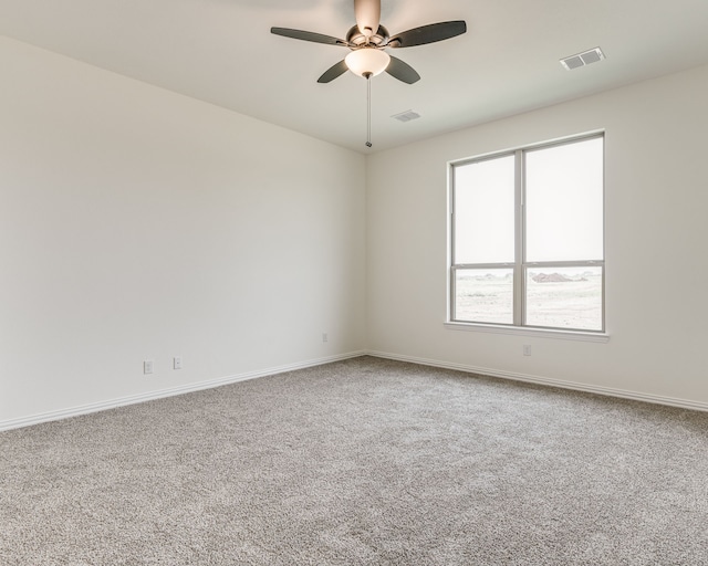 empty room featuring ceiling fan and carpet